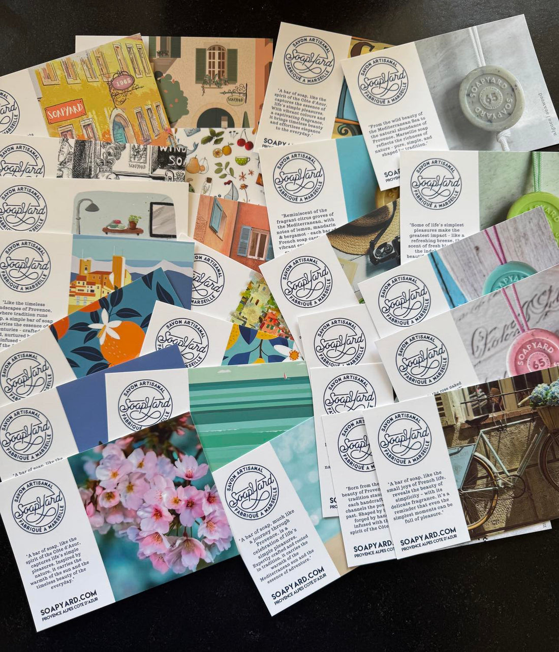 A flatlay of Soapyard soap brand promotional cards featuring colourful designs inspired by Provence and the Côte d’Azur, with the Soapyard logo and storytelling-style descriptions on each card.