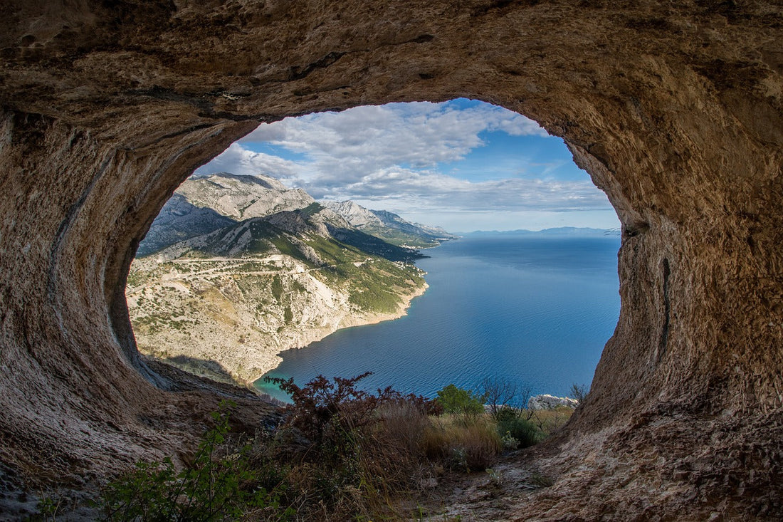 view of dalmatian coast in croatia through a natural hole n a wall or cave