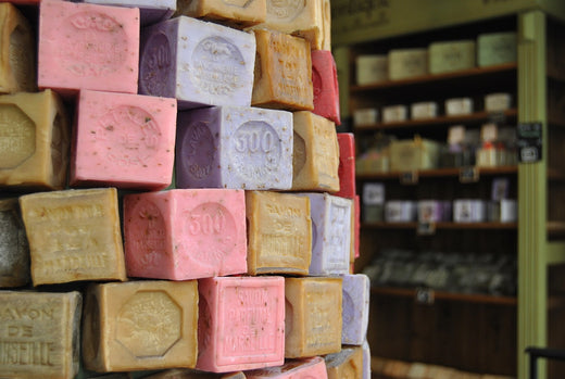 pile of marseille soap cubes in various colours, pink for rose, lavender , olive oil green