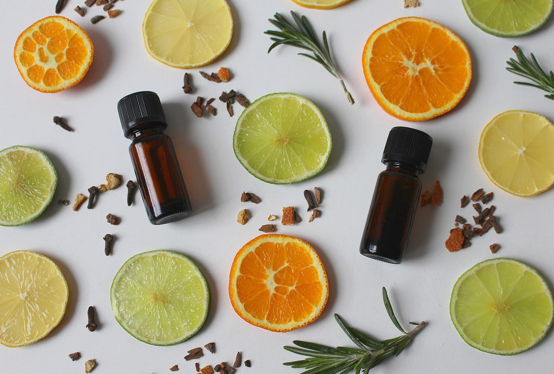 bottle for essential oils surrounded by orange and lime slices