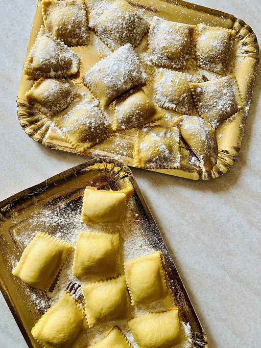 freshly made ravioli still on a floury board